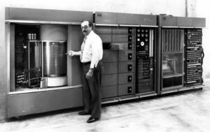 A picture of a man standing near a non sharing time computer. (great career fields for the future)